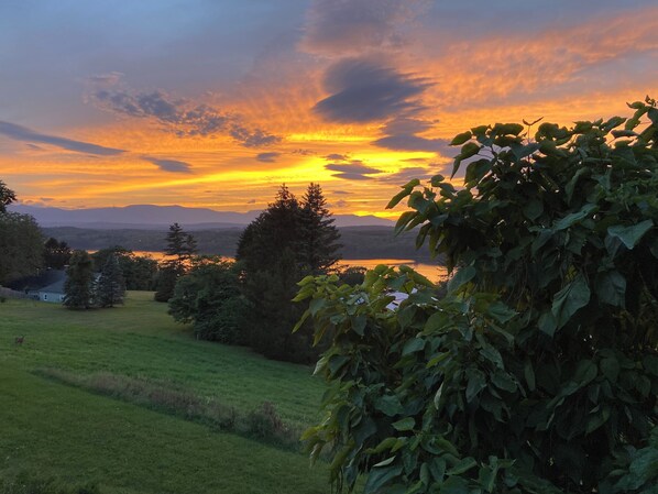 A sunset over a lake with trees and a house in the foreground. - An Apartment with a View: A peaceful getaway in Hudson, NY (Hudson)