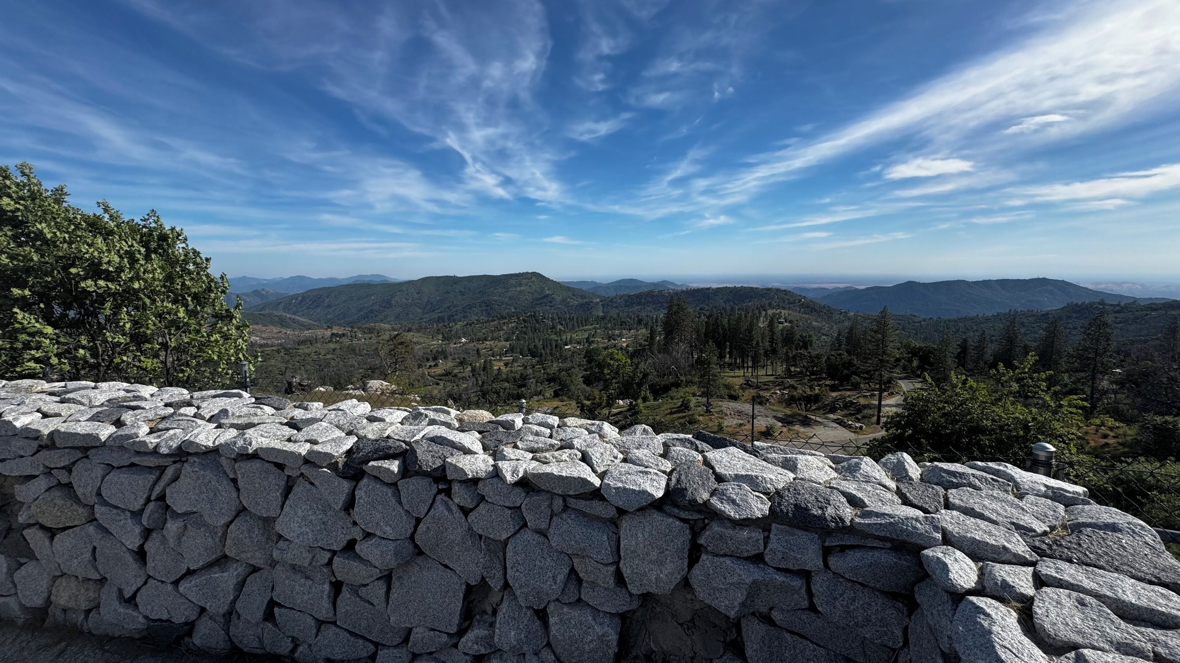 A stone wall with a view of a mountainous landscape.