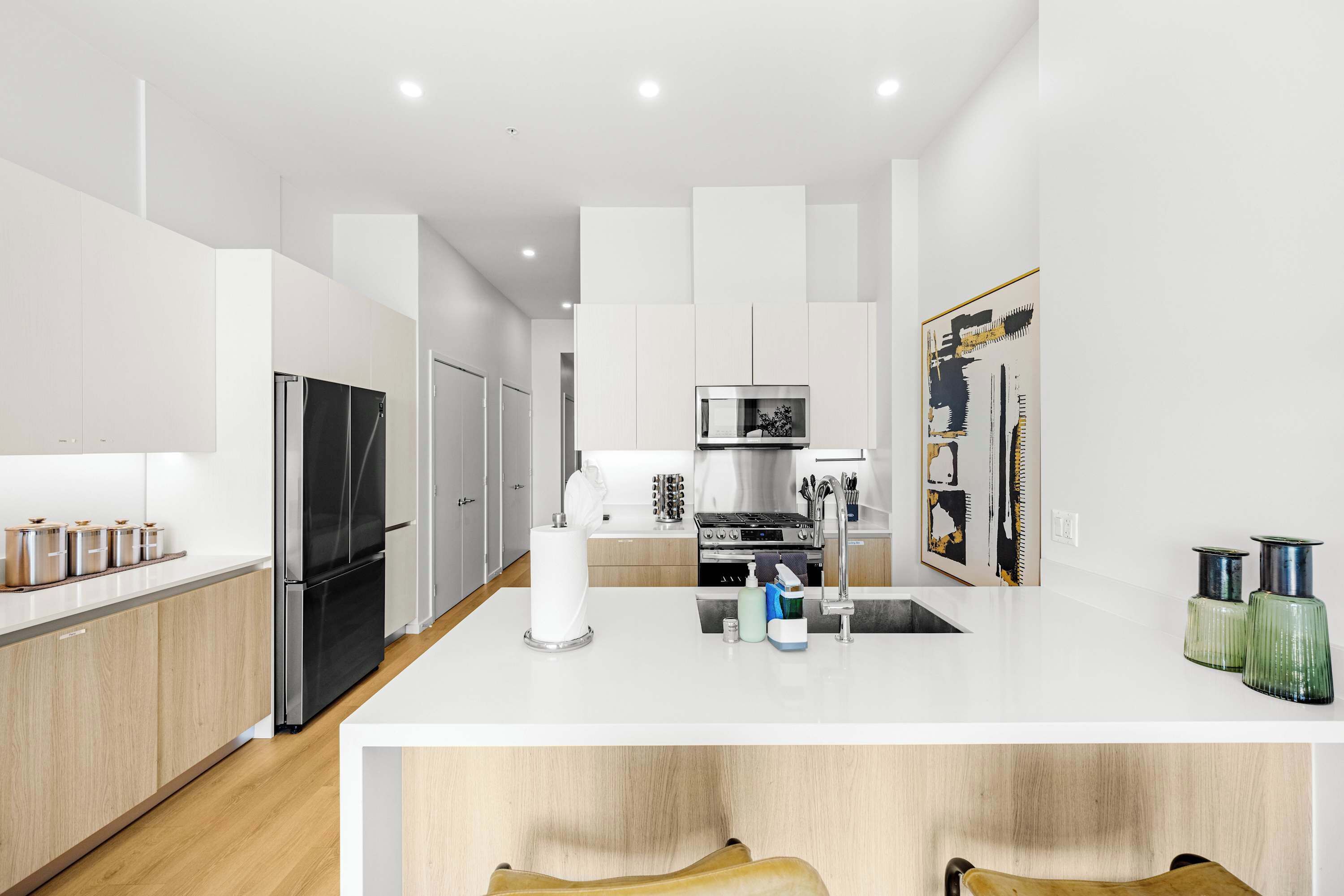 Una cocina moderna con una isla central, electrodomésticos de acero inoxidable y un diseño minimalista.