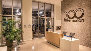 A reception area with a modern design, including a reception desk, a large potted plant, and a wall with the text "200 west ocean".