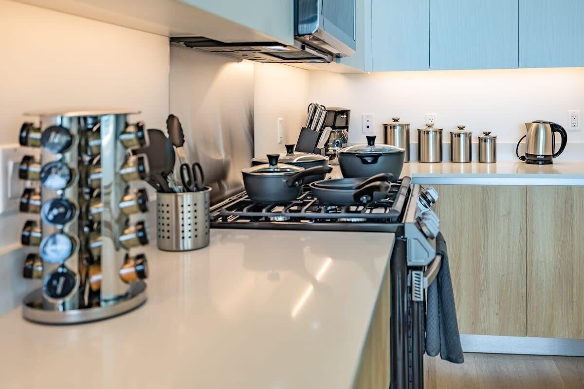 A modern kitchen with stainless steel appliances, a gas stove, and a variety of cookware.