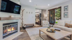 A modern living room with a fireplace, a flat-screen TV, a sofa, and a coffee table.