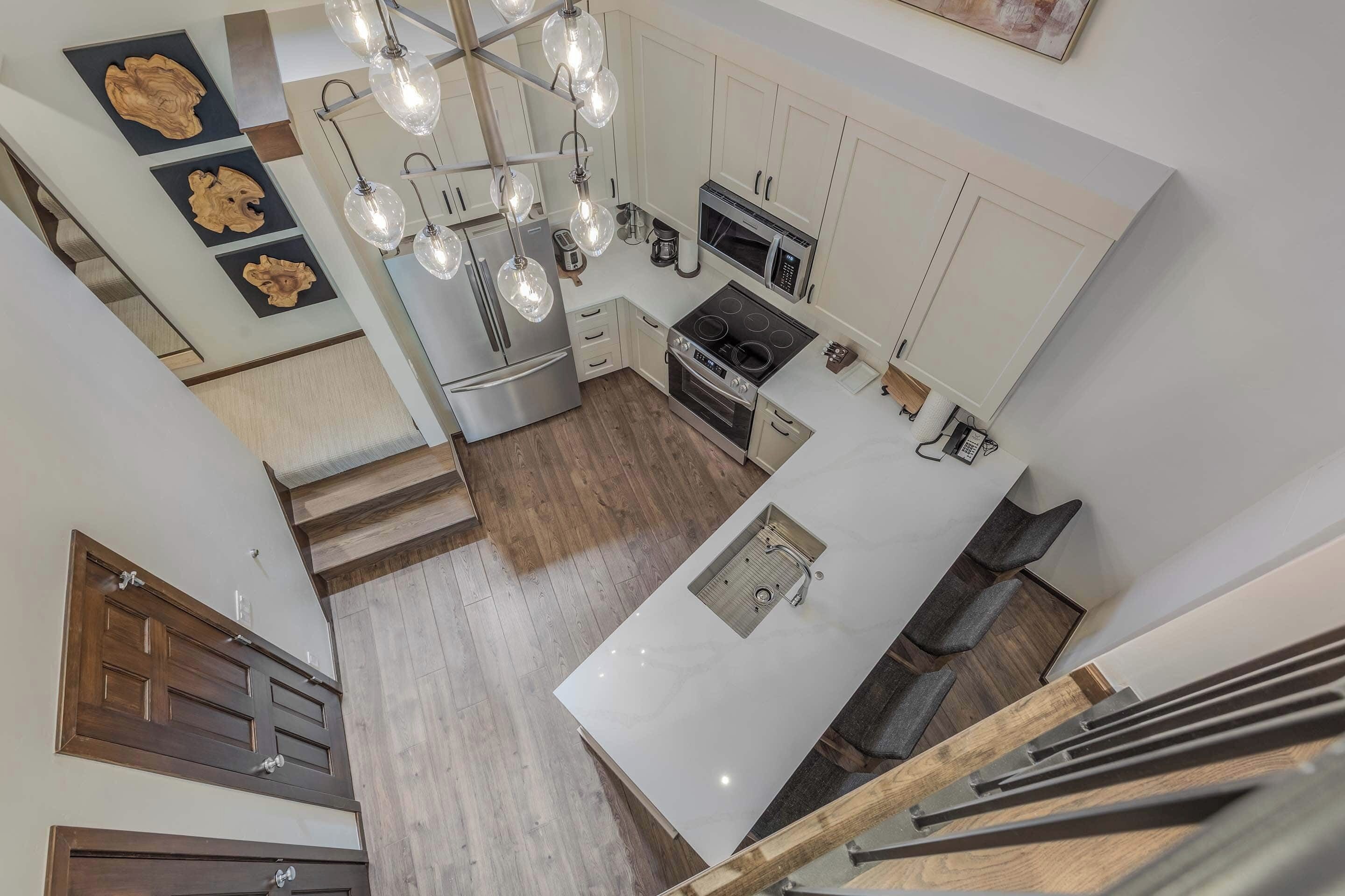 A modern kitchen with white cabinets, stainless steel appliances, and a central island.