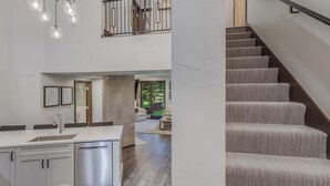 A modern kitchen with a built-in dishwasher and a dining area with a large window.