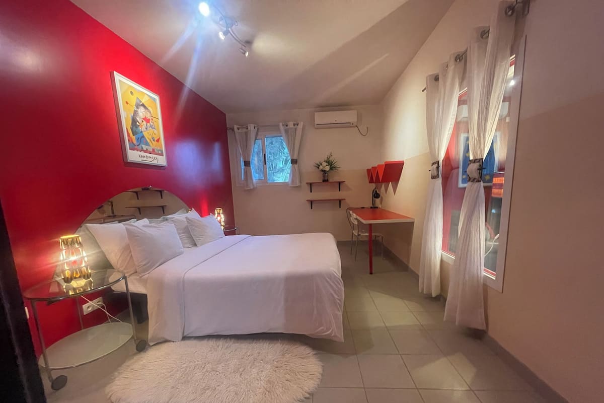 Une chambre à coucher avec un lit, un bureau et une fenêtre.