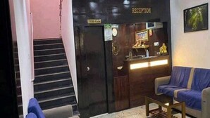 A reception area with a reception desk, a staircase, and a seating area with a sofa and a small table.