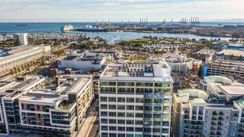 A coastal cityscape with modern buildings, a marina, and industrial facilities.