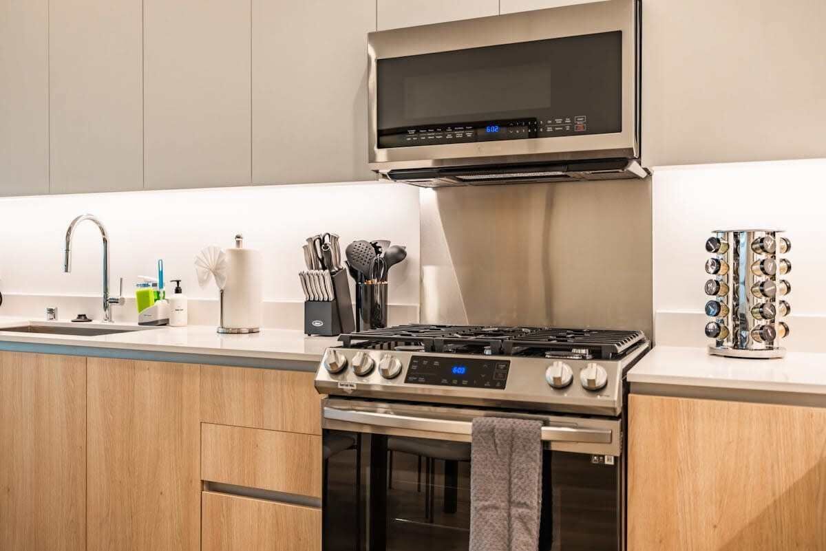 A modern kitchen with a stainless steel stove, oven, and microwave.