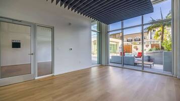 Quarto espaçoso com uma grande porta de vidro que se abre para área externa com piscina e área de estar.