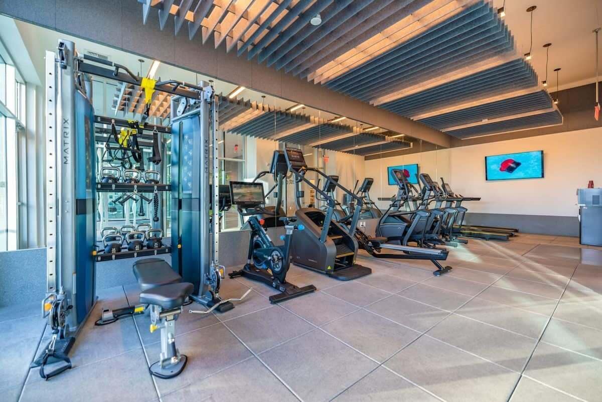 Een moderne fitnessruimte met diverse trainingsapparaten, waaronder loopbanden en krachttoestellen.