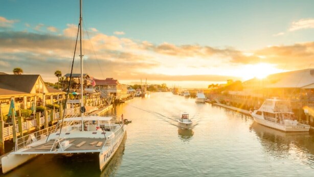 A marina with boats docked, a clear sky, and buildings along the water. - Charming 3br/2ba Shem Creek Oasis! (Mount Pleasant)