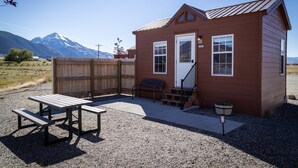 A small wooden cabin with a porch, picnic table, and bench. - Mayfly Cabin (Cabin #3) (Park County)