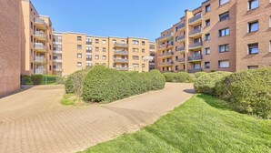 A residential building with multiple floors, balconies, and a paved pathway. - Marta - Stylish Temporary Living in Bergheim (Bergheim)