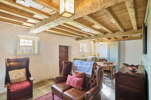 Cozy retreat with a leather armchair, wooden dining table, and kitchen area.