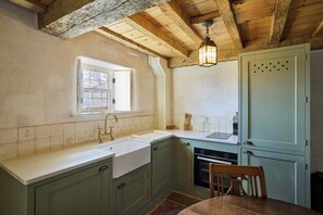 Traditional kitchen with a rustic charm, featuring a sink, stove, and classic cabinets.