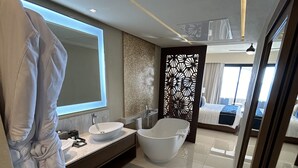 A modern bathroom with a bathtub, a large mirror, and a vanity with a sink. - Gorgeous Oceanfront 2BR Cabo Rental – Ocean Views, Infinity Pool & Luxe Vibes (San José del Cabo)