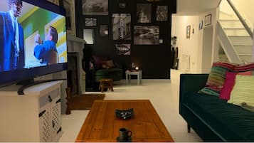 Smart TV, lareira, livros, aparelho de som