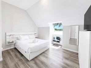 Ein modernes Schlafzimmer mit einem großen Bett, einem Nachttisch und einem Sessel.