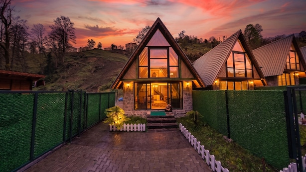 Una casa moderna con techo triangular, ventanas amplias y entrada empaveda.