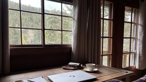 Un bureau en bois avec un ordinateur portable, un carnet et une tasse.