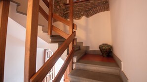 Escadas com corrimãos de madeira e paredes de pedra.