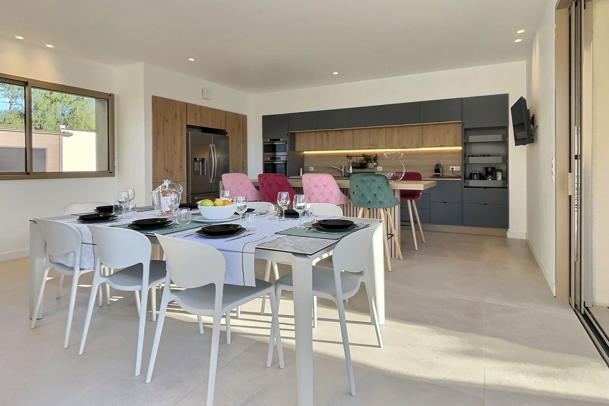 A modern kitchen with grey cabinets, a built-in oven, and a microwave.