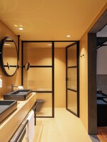A modern bathroom with two sinks, a mirror, and a towel rack.