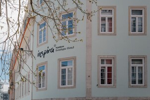 A building with multiple windows, a sign reading 'Santos Boutique Hotel,' and a visible door.