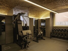 Una palestra con attrezzature per esercizi, una TV a muro e una finestra con vista.