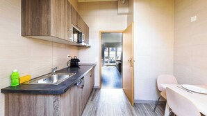 Una cucina moderna con mobili in legno, un piano di lavoro nero e un lavello in acciaio inossidabile.