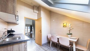 Una cucina moderna con piano cottura integrato, lavello e zona pranzo con tavolo e sedie.