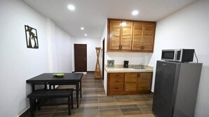 Eine kleine Küche mit Holzausstattung, einem Kühlschrank und einem Esstisch mit Bänken.