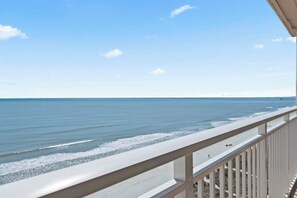 Een balkon met uitzicht op het strand en de oceaan.
