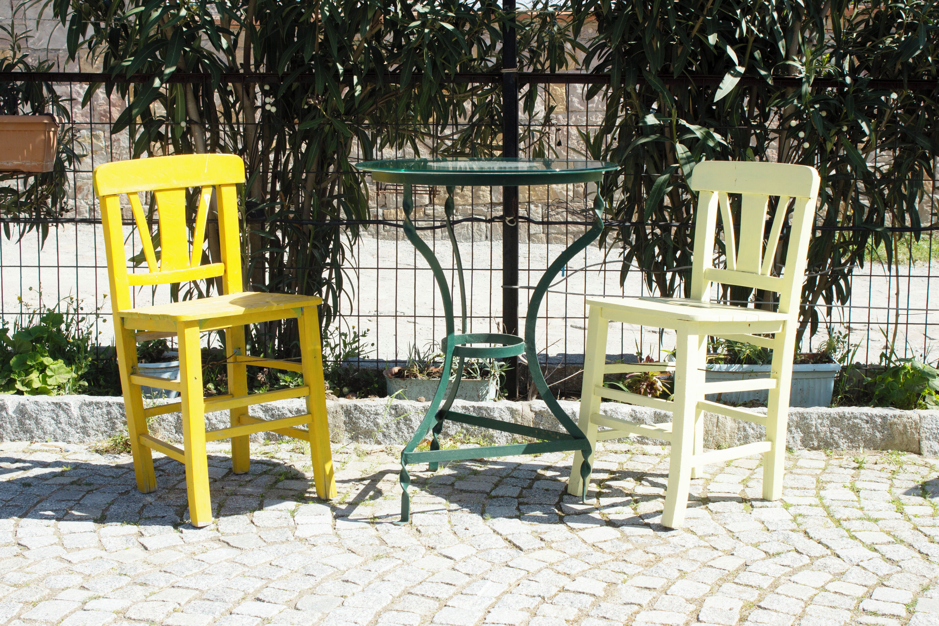Deux chaises et une table sur une surface pavée.