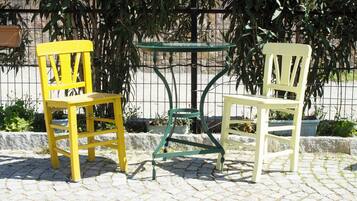 Deux chaises et une table sur une surface pavée.