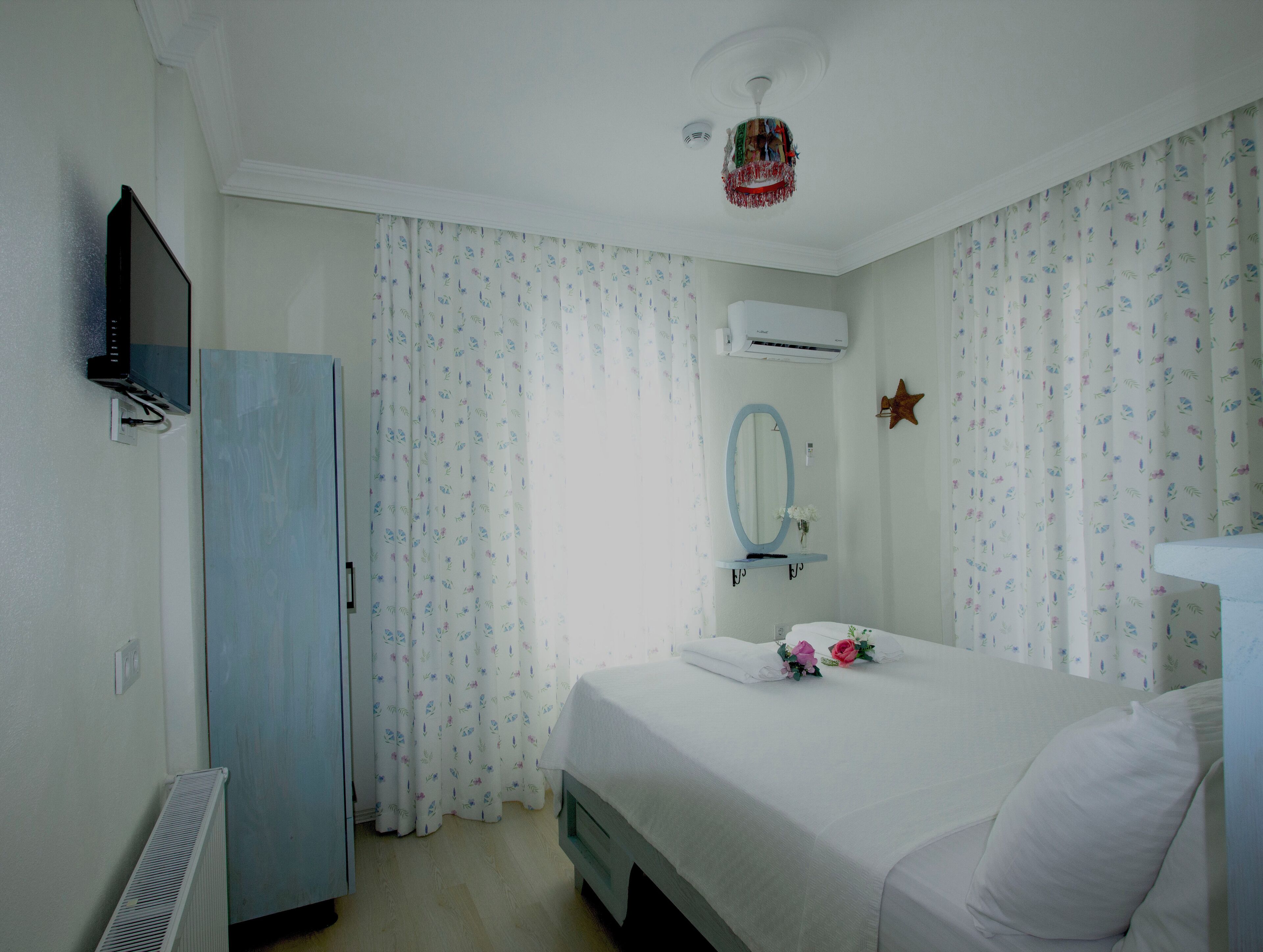 A bedroom with a bed, a dresser, a mirror, and a ceiling fan.
