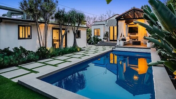 A modern house with a swimming pool, a patio, and a covered outdoor seating area.