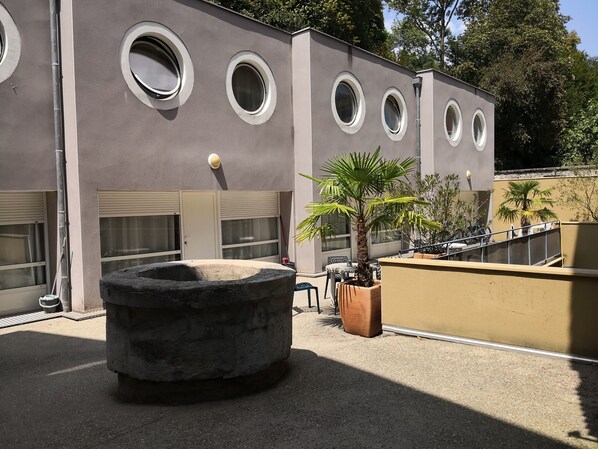 Un edificio con ventanas circulares, una gran estructura de piedra y una palmera.