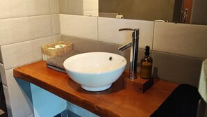 A modern bathroom with a wooden vanity, a white sink, and a mirror above it. - Cabane Isabelle - Ile aux Cabanes 2 pers (STE COLOMBE)