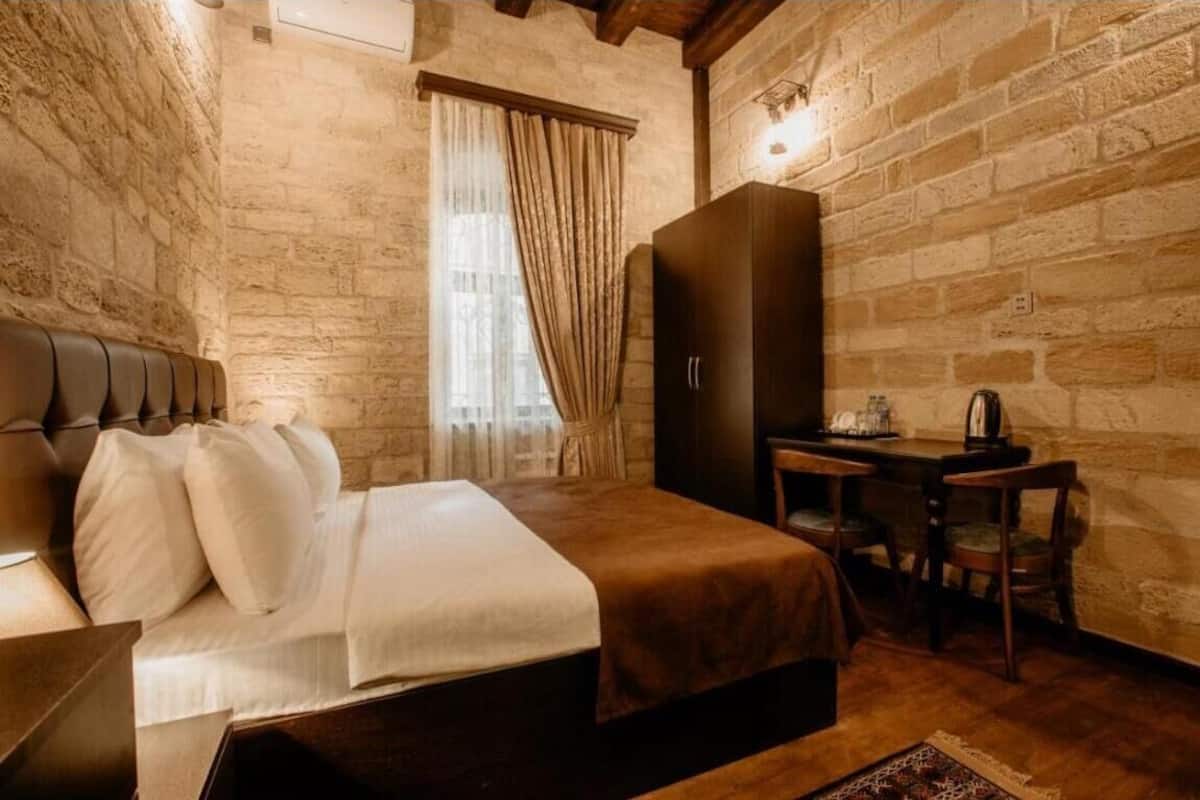 Una camera da letto con un letto, una scrivania e un armadio.