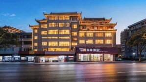 A hotel with traditional architecture, multiple floors, and a well-lit facade. - Home Inn Huayi Hotel (Wudangshan Jingqu Rukou Road) (Danjiangkou)