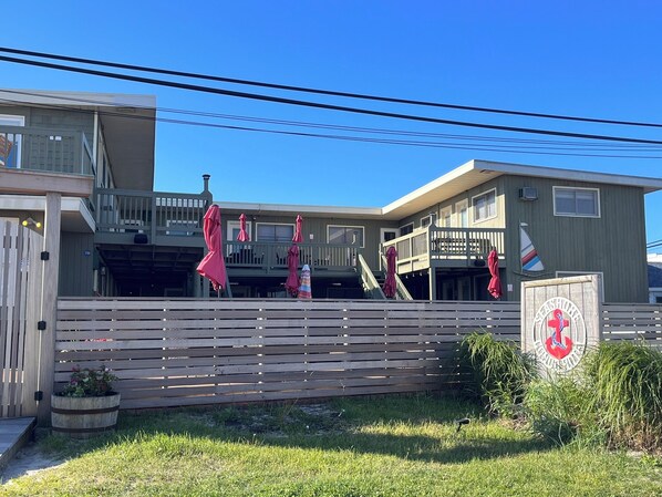 A two-story building with a wooden deck and a sign that reads "SeaShore Inn".