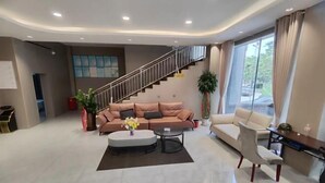 A modern living room with a sofa, coffee table, and a dining area. - Holiday Inn (Yanqi)