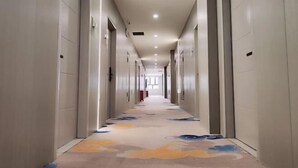 A long, narrow hallway with doors on both sides, leading to individual rooms. - Holiday Inn (Yanqi)
