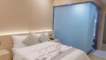 Quarto de hotel moderno com cama, mesa de cabeceira e uma porta deslizante azul.