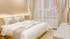 A hotel room with a bed, a bedside table, and a window with sheer curtains. - Holiday Inn (Yanqi)