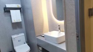 A modern bathroom with a toilet, sink, and towel rack.