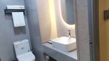 Casa de banho moderna com sanita, lavatório e porta-toalhas.