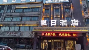 A hotel facade with illuminated signage, a contact number, and a traditional architectural style. - Holiday Inn (Yanqi)