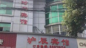 A hotel with a prominent red sign and a contact number. - Huchen Fashion Hotel (Shanghai)